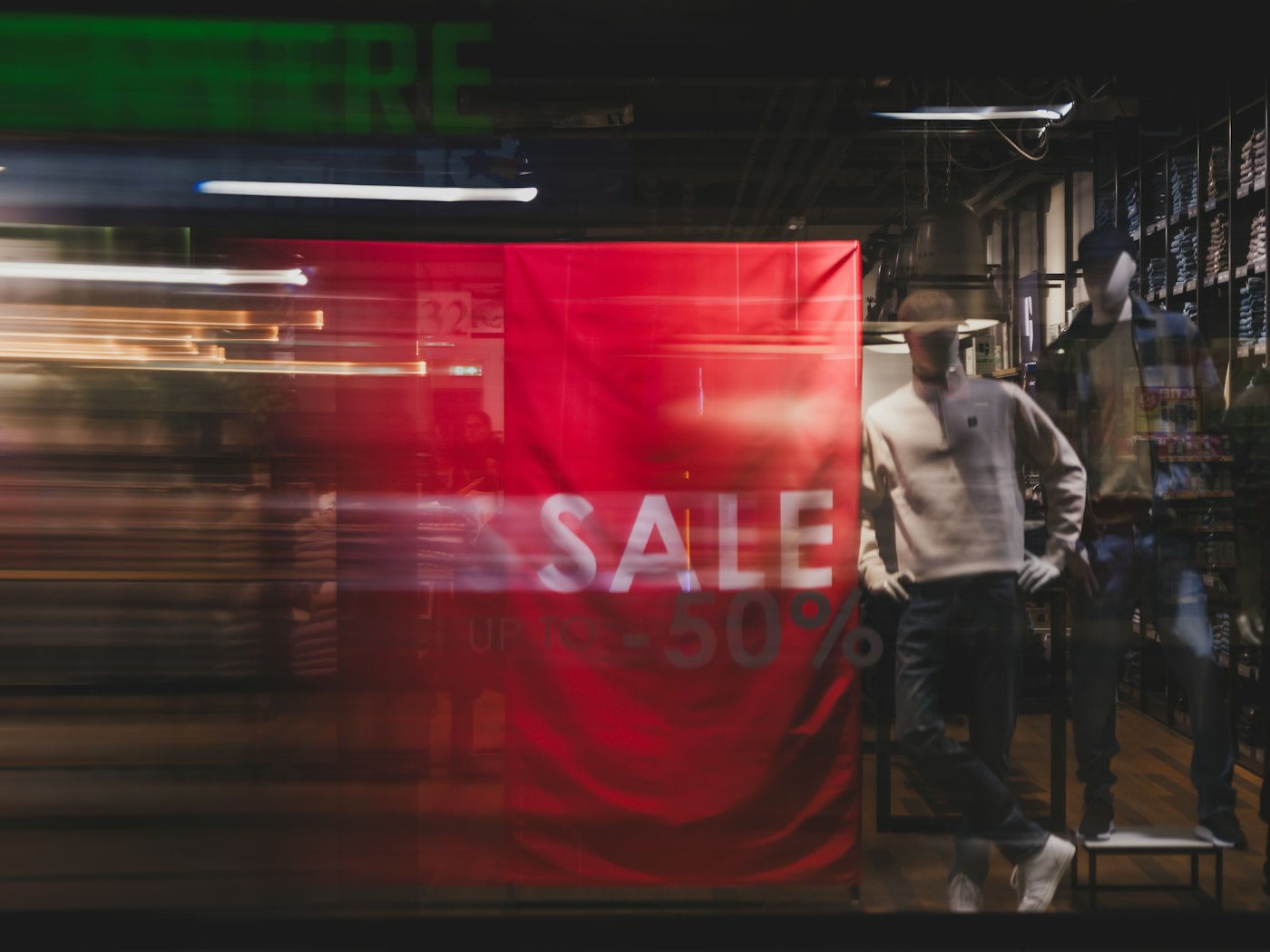 A fashion shop window with a red banner reading sale, up to minus 50 percent
